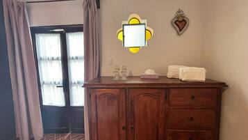 Une salle de bain avec un meuble-lavabo en bois, un miroir, un porte-serviettes et un élément décoratif mural.