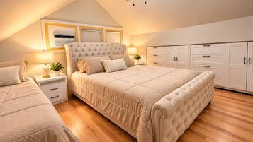 A bedroom with a large bed, bedside tables, a ceiling fan, and built-in wardrobes.