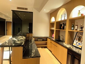 A modern kitchen with a marble countertop, wooden cabinets, and a wine rack. - Brand new 2026 designer construction- Full privacy-Gym-Sauna-Hotel bar- Firepit. (East Hampton)