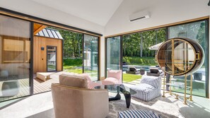 En modern inredning med stora glasfönster, en rund spegel och utsikt över en swimmingpool.