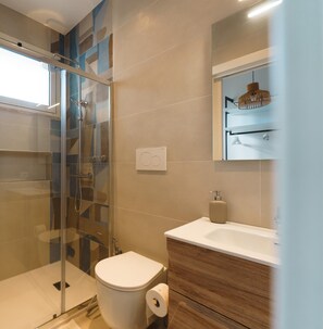 A modern bathroom with a glass-enclosed shower, a toilet, and a vanity with a mirror. - “Azure” room – Puglia Ospita – Otranto (OTRANTO)