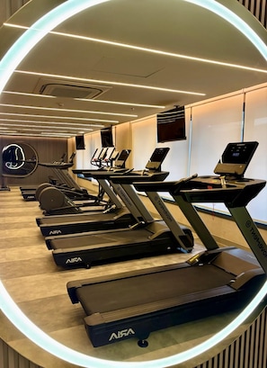 A gym with multiple treadmills and exercise equipment, arranged in a modern, well-lit room with a wooden floor. - New studio apartment in Cidade Baixa, near Redenção Park and UFRGS (Federal University of Rio Grande do Sul). (Porto Alegre)