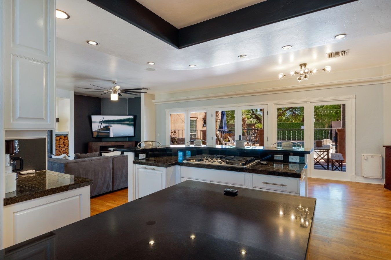 A modern kitchen with a central island, built-in appliances, and a view to an outdoor patio area.