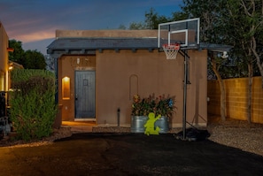 A residential property with a basketball hoop, a door, and a small garden area.