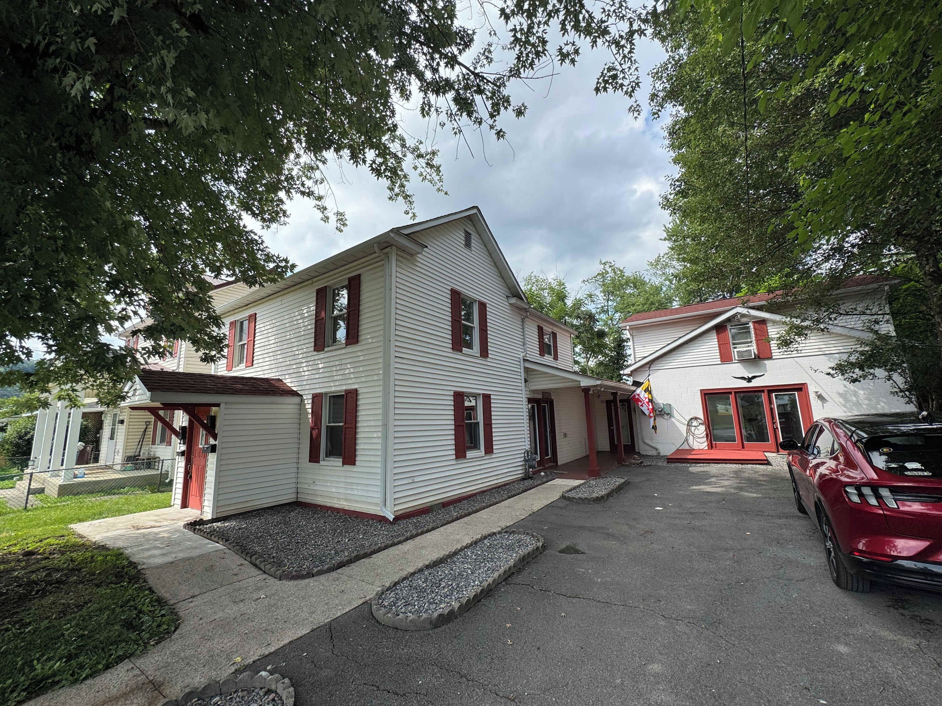 Ein zweistöckiges Wohnhaus mit roter Tür und Garage.
