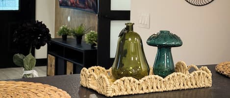 A modern interior with a woven basket centerpiece, a flat-screen TV, and a geometric light fixture.