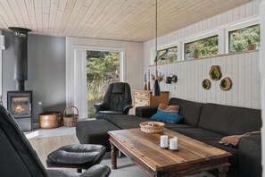 A cozy living room with a fireplace, leather furniture, and a wooden coffee table. - Holiday home near the beach on Rømø (Rømø)