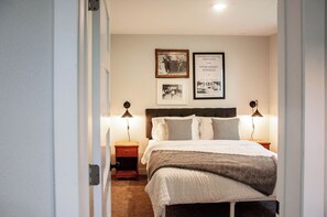 A bedroom with a bed, two bedside tables with lamps, a headboard, and two framed pictures on the wall. - Charming Crookston Cottage (Crookston)
