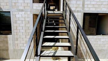 Eine Treppe mit Metallgeländern, die zu einer offenen Tür führt.