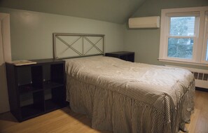 A bedroom with a bed, a headboard, a window, and built-in shelving. - Spacious 3-Bedroom House in Boston with Free Parking (Boston)