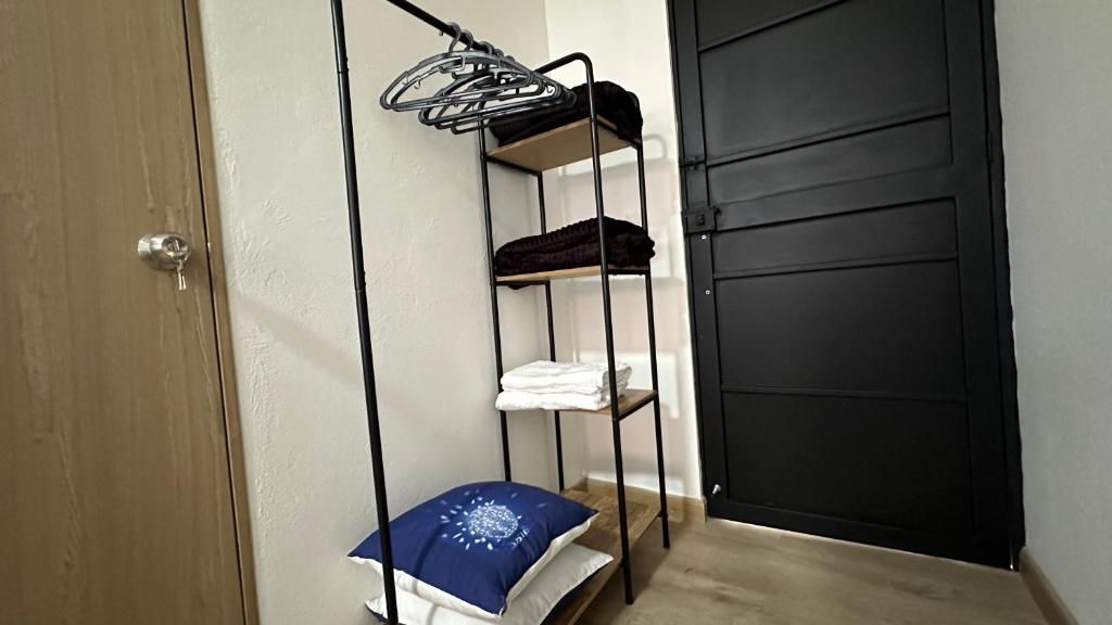 Una habitación con literas, una puerta y una pequeña mesa con cojín.