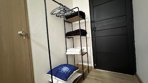A room with a bunk bed, a door, and a small table with a cushion. - Sinu Loft (Medellín)