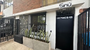 A building with a black door labeled 'CR 71#C 5-13' and a sign above it. - Sinu Loft (Medellín)