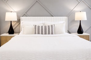 A neatly made bed with a white headboard and two bedside lamps. - Villa Paradise PalmeraPrivate Pool Oasis (Port Charlotte)