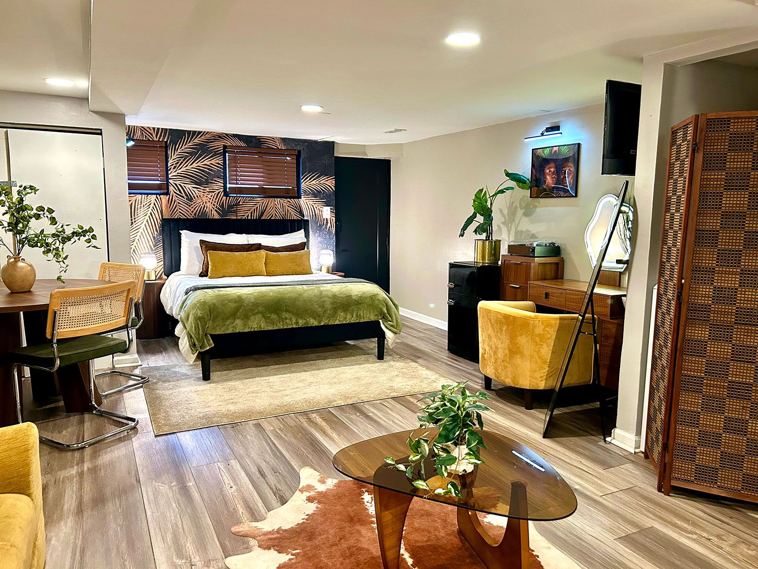A modern bedroom with a bed, bedside tables, a desk, and a chair.