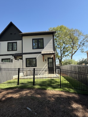 A two-story house with a black roof, white siding, and a black fence in front. - Homewood Luxury 2 Bedroom 2 Bath Townhome 3020 (Homewood)