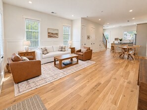 A spacious living room with a white sofa, brown armchair, and wooden coffee table. - Homewood Luxury 2 Bedroom 2 Bath Townhome 3020 (Homewood)