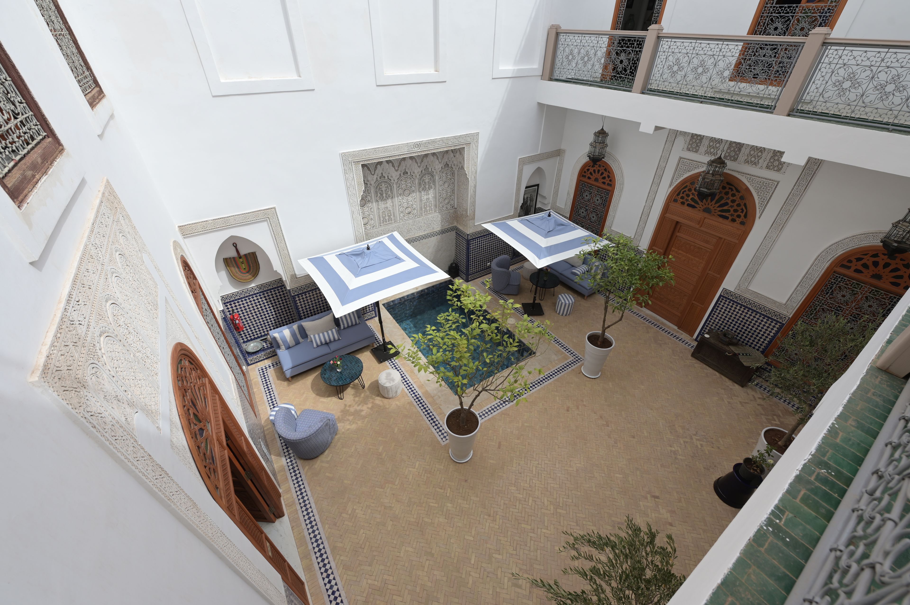 Un patio con piscina, zona de estar y elementos decorativos.