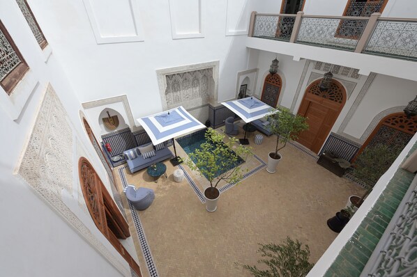 A courtyard with a pool, seating area, and decorative elements. - Riad Du Lion De L'Atlas (Marrakech)