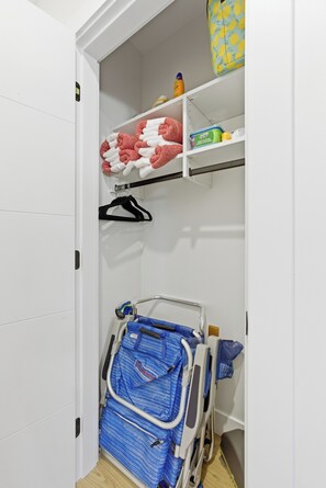 A closet with a bed, a shelf with folded towels, and a toiletry bag. - Carriage on Richter •2 King Beds• Sleeps 6 • Ski Base • Close to Hospital (Kelowna)