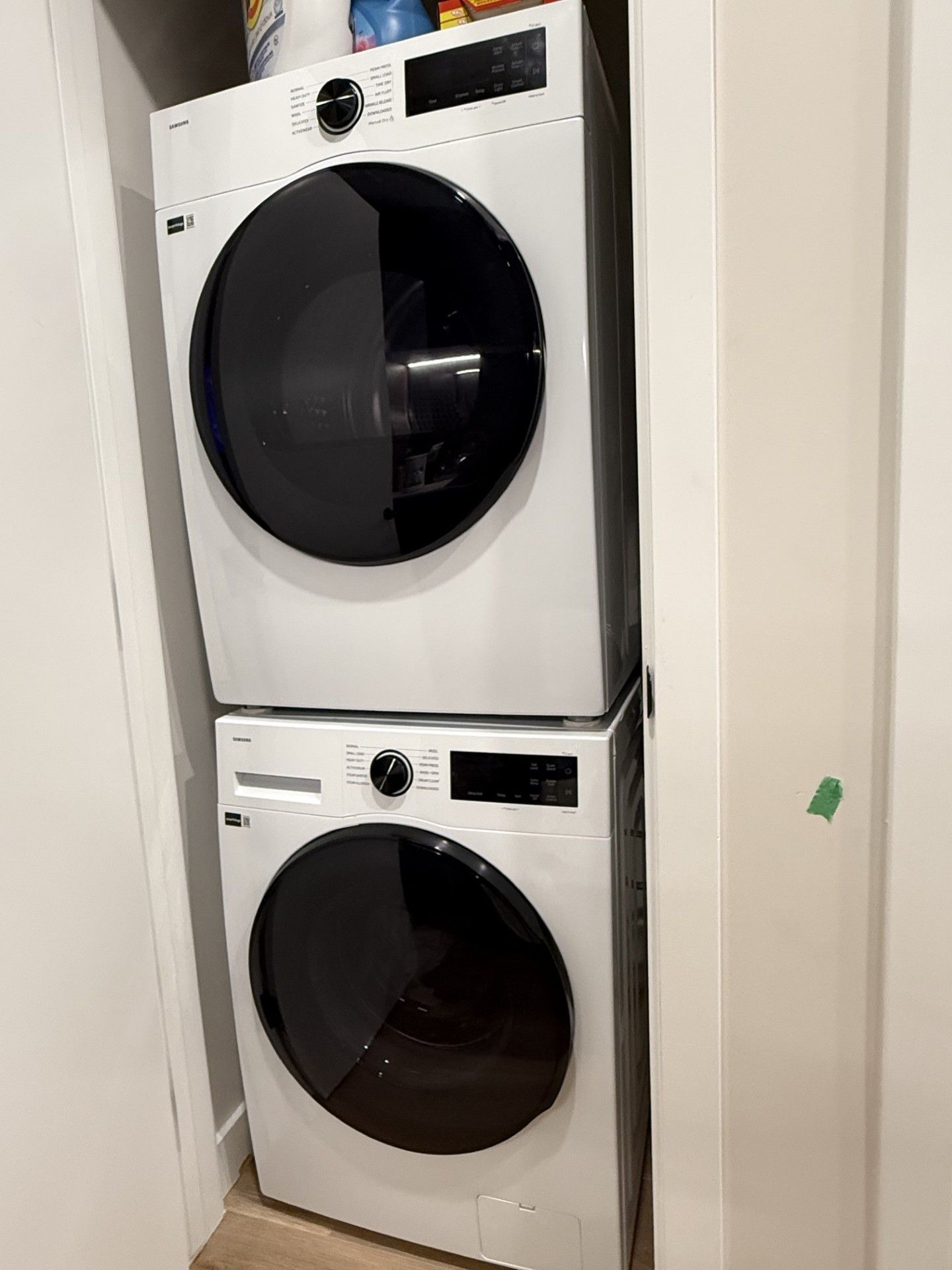 Two stacked front-loading washing machines in a corner.