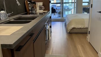 A modern kitchen with a built-in oven, a sink, and a coffee maker.