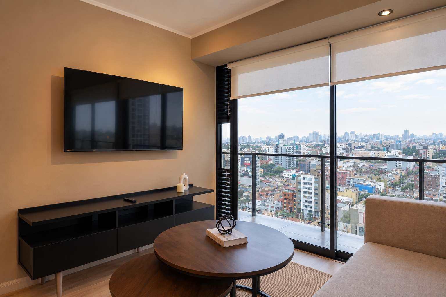 Una sala de estar moderna con un televisor grande, una mesa redonda y un sofá.