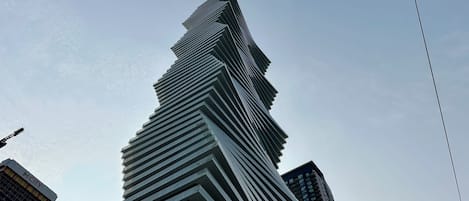 A high-rise building with a unique angular design, surrounded by other modern structures.