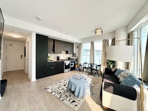 A modern apartment with a kitchen, dining area, and living room. - The Modern Retreat | Luxury 2 Bed, 2 Bath Condominium (Mississauga)