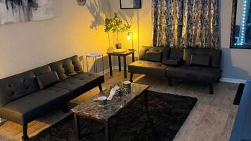 A modern living room with a sofa, a coffee table, and a potted plant.