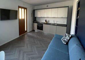 Eine moderne Küche mit weißen Schränken, einem eingebauten Ofen und einer Spüle.