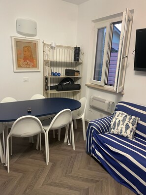 A compact living space with a dining table, chairs, a sofa, and a window. - A 13-minute bike ride from downtown Forte dei Marmi: apartment with a terrace (Ripa- Pozzi-Ponterosso)