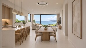 Eine moderne Küche mit Essbereich, großen Fenstern und Meerblick.