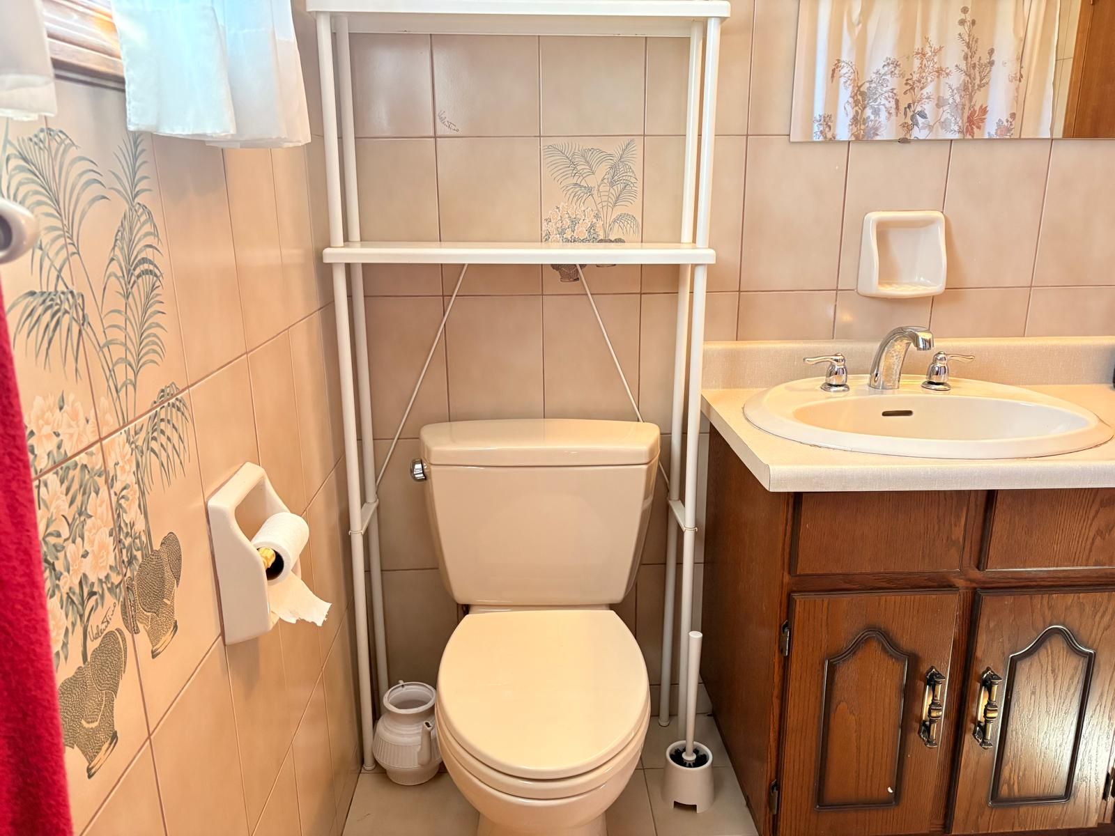 A bathroom with a toilet, a sink, and a cabinet.
