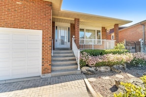 A two-story house with a garage, a covered porch, and a landscaped front yard.