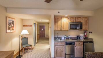 A compact kitchen with wooden cabinets, a microwave, and a dishwasher.