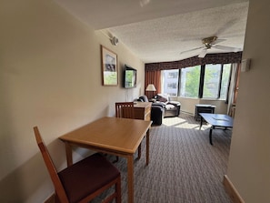 A hotel room with a dining table, chairs, a sofa, a small table, and a ceiling fan. - NEW LISTING - 379-381 2-Bdrm Suite @ Base Area Mt. Crested Butte (Crested Butte)