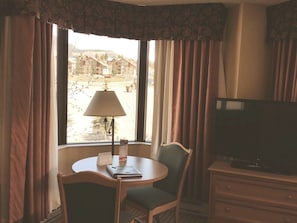 A hotel room with a television, a table with a lamp, and a view of the outside. - NEW LISTING - 379-381 2-Bdrm Suite @ Base Area Mt. Crested Butte (Crested Butte)