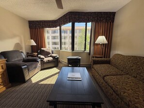 A hotel room with a sofa, armchair, and a small table with a laptop. - NEW LISTING - 379-381 2-Bdrm Suite @ Base Area Mt. Crested Butte (Crested Butte)