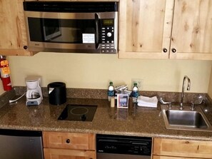 A kitchen with a built-in microwave, a coffee maker, a sink, and wooden cabinets. - NEW LISTING - 379-381 2-Bdrm Suite @ Base Area Mt. Crested Butte (Crested Butte)
