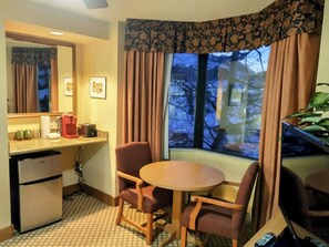 A compact hotel room with a kitchenette, a dining area with two chairs, a small table, and a window with curtains. - NEW LISTING - 281 Slopeside King Bed Studio, views, Pet friendly (Crested Butte)