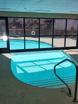 A swimming pool with clear blue water, surrounded by a tiled deck and a metal safety railing. - NEW LISTING - 281 Slopeside King Bed Studio, views, Pet friendly (Crested Butte)