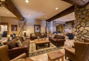 A spacious living room with leather sofas, a coffee table, and a stone accent wall. - NEW LISTING - 279 Slopeside King bed Studio Pet friendly! (Crested Butte)
