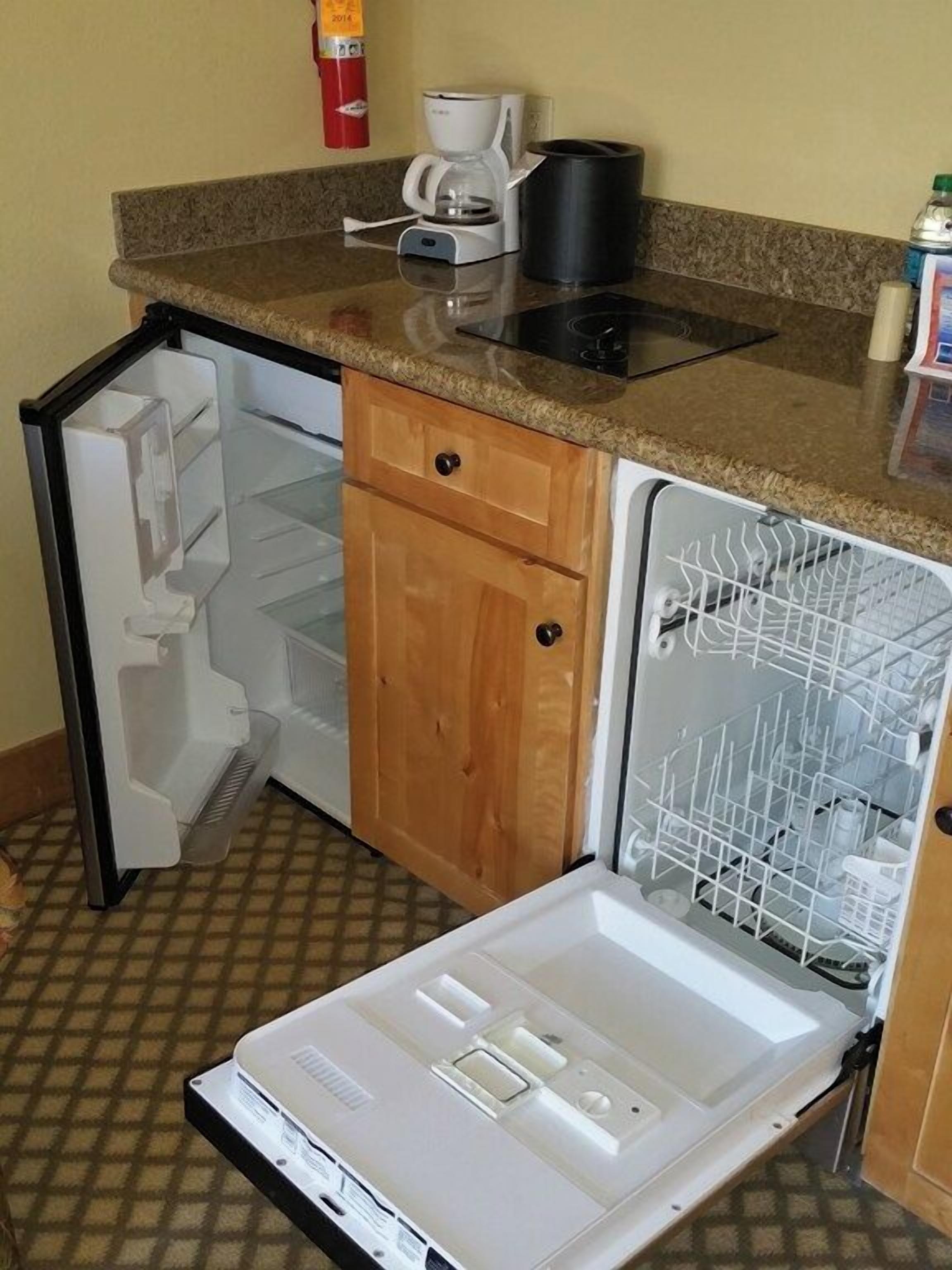 Una cocina compacta equipada con lavavajillas, cafetera y refrigerador pequeño.