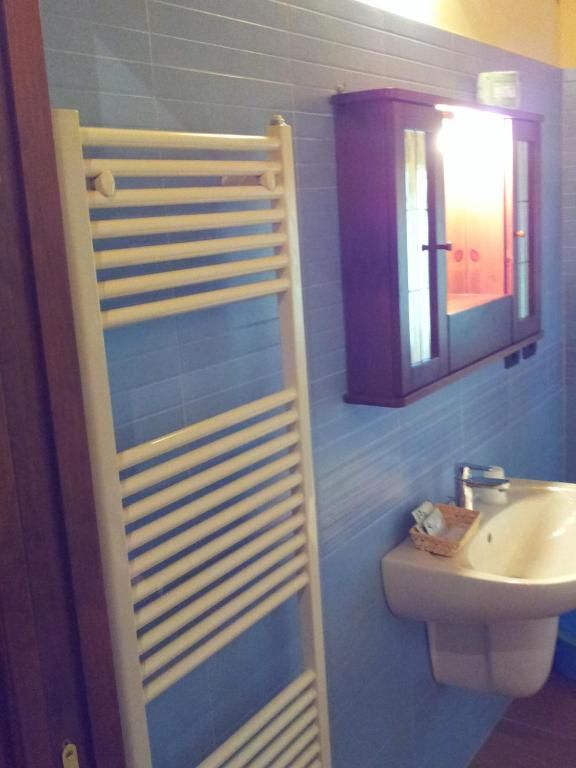 A bathroom with a towel rack, a cabinet, and a sink.