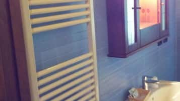 A bathroom with a towel rack, a cabinet, and a sink.