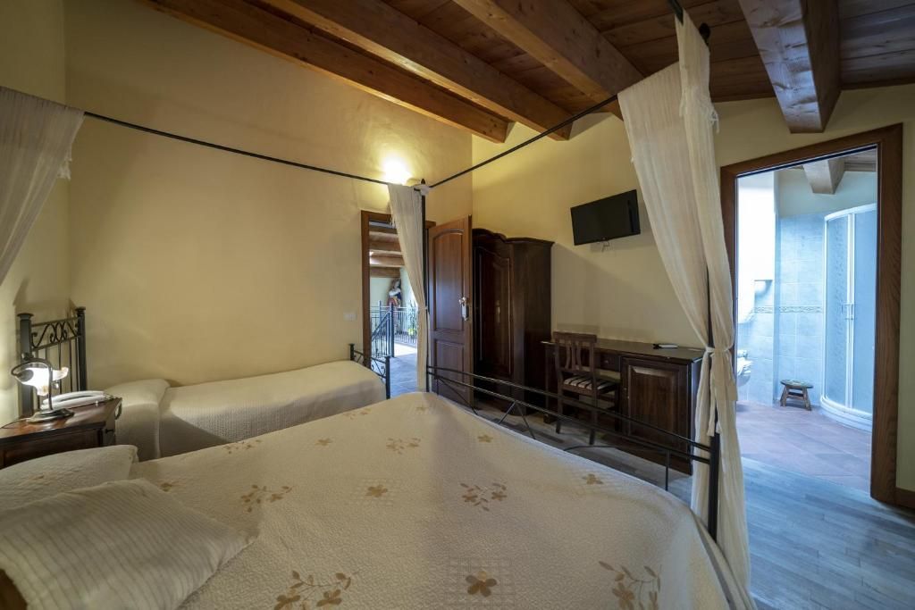 A bedroom with a bed, a desk, and a chair. There is a balcony with a view.