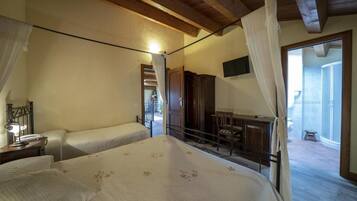 Una camera da letto con un letto, una scrivania e una sedia. C'è un balcone con vista.