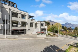 Ein modernes Gebäude mit Garage, einem Restaurant namens 'Globe' und Blick auf Berge im Hintergrund.