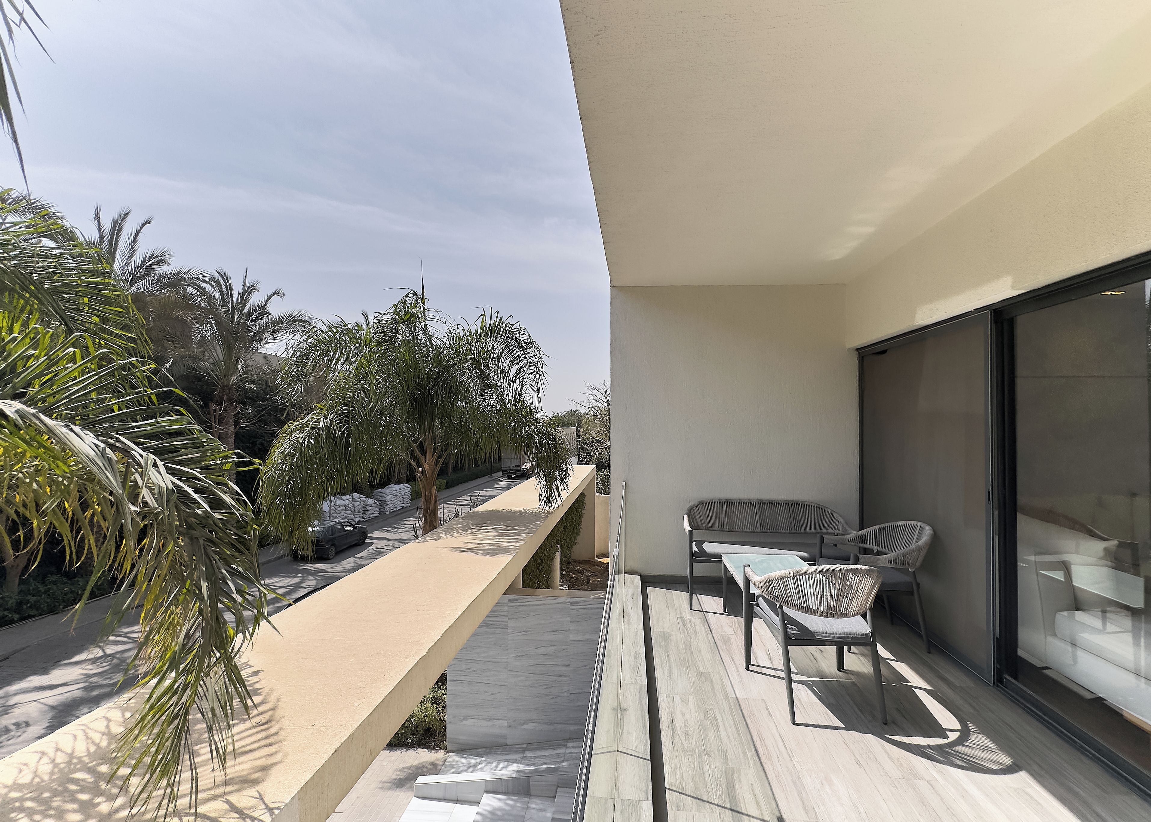 Un balcon avec un coin salon, une petite table et un canapé.